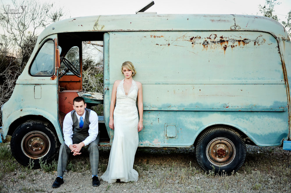 alternative photograph of bride and groom in front of old beat up van in their wedding clothes