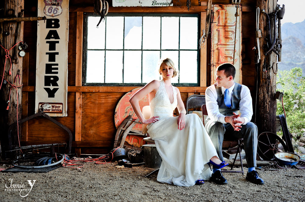 trash the dress photograph of bride and groom at nelson ghost town in nevada sitting on chairs in abandoned funky building