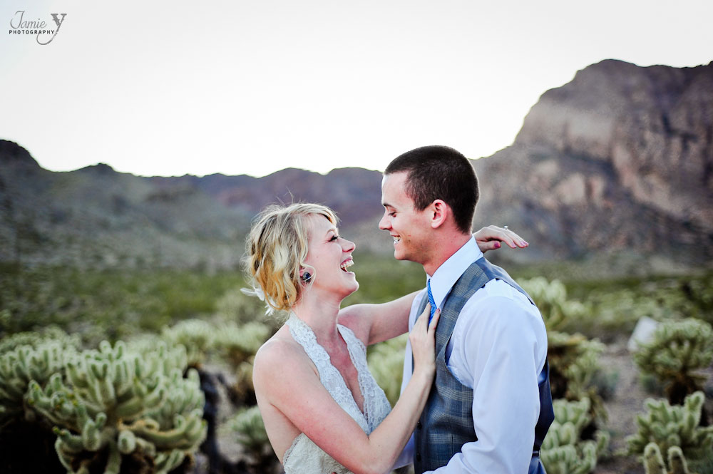 Bride and groom laughing in desert with awesome cactus in background