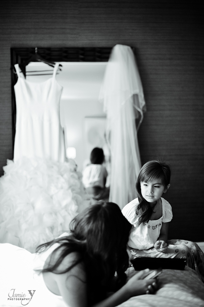 flower girl with wedding dress hanging in background