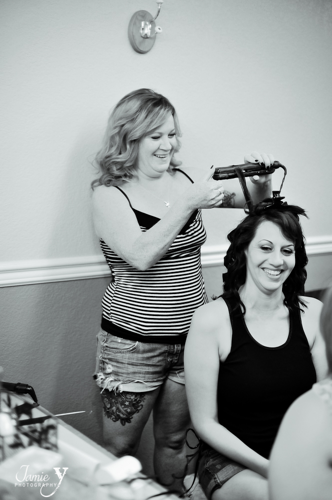 bride smiling as she gets her hair done on wedding day