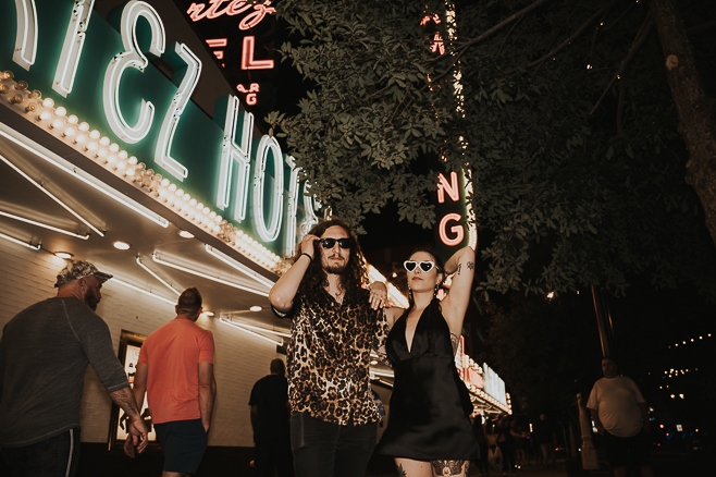 couple looking cool in sunglasses after getting married standing in front of el cortez in downtown las vegas