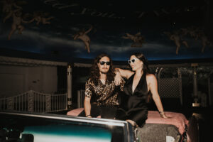 bride and groom sitting in pink cadillac outside las vegas little white chapel