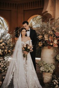 bride and groom standing at altar of flowers at amanjena morocco for wedding