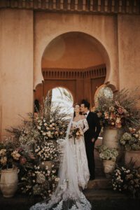bride and groom standing at altar of flowers at amanjena morocco for wedding