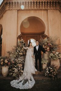 bride and groom standing at altar of flowers at amanjena morocco for wedding
