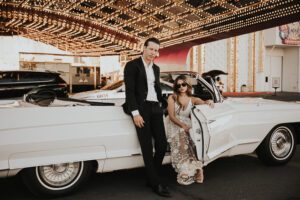 bride and groom in vintage convertible car in front of circus circus in las vegas