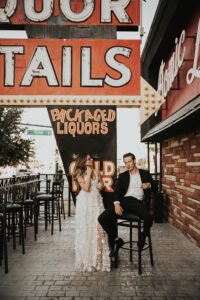 bride and groom in front of atomic liquor neon sign downtown las vegas