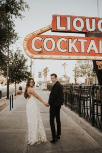 bride and groom in front of atomic liquor neon sign downtown las vegas