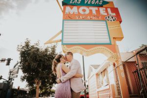 bride and groom kissing in front of a las vegas motel vintage sign downtown