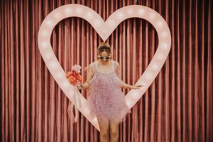 bride in pink dress in front of heart at sure thing chapel in las vegas