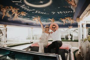 bride and groom in pink cadillac ceremony at little white chapel