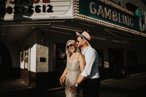 warm backlit photo of bride and groom in downtown las vegas with neon signs behind