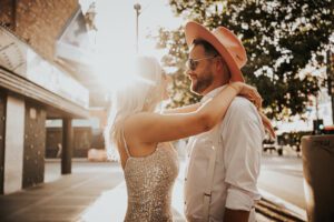 warm backlit photo of bride and groom in downtown las vegas with neon signs behind