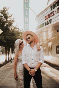 warm backlit photo of bride and groom in downtown las vegas with neon signs behind