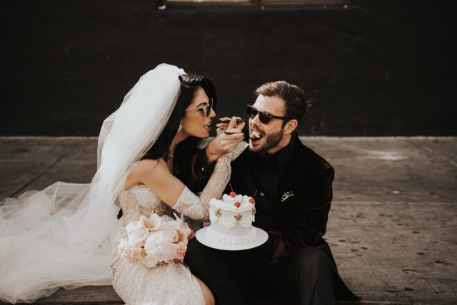 wedding couple in las vegas eating wedding cake on the curb